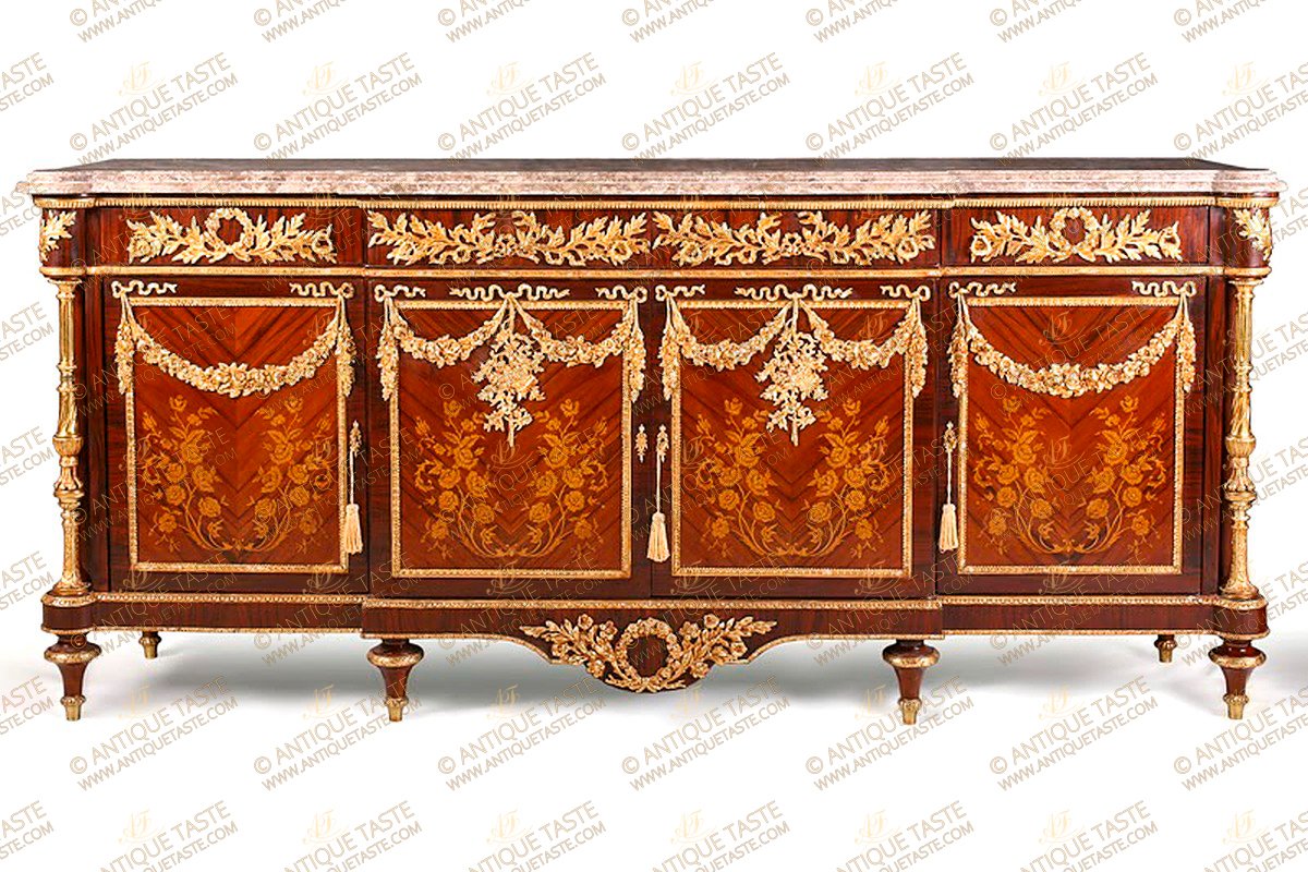 A Grand and Royal French Louis XVI style ormolu-mounted veneer and marquetry inlaid Buffet À Vantaux after the model Frédéric Durand and Sons, based on a model by Martin Carlin, Paris, Last Quarter 19th Century, The large two meter breakfront shaped eared marble top above a conforming case set with frieze drawers ornamented with swags and ribbon-tied loose bouquets pierced interlaced laurel garlands, the sides similarly decorated, Over four cupboard doors, Each door is decorated with an ormolu keyhole escutcheon and inlaid with naturalistic flowers marquetry patterns, the paneled doors hung with ormolu blossoming pendant garlands, the sides are sans traverse veneer inlaid, The angles with astonishing gilt-ormolu turned fluted colonnettes angle supports called chinoises over an arbalette shaped apron centered with an ormolu ribboned-shape blossoming floral wreath and raised on ormolu decorated six toupie feet. The luxurious buffet is a part of a dining set